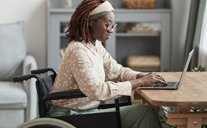 Woman in a wheelchair working on a laptop